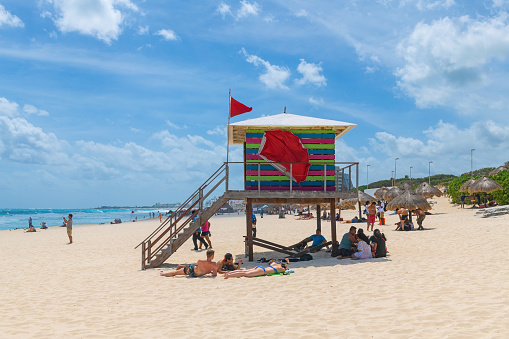 Lifeguard post tower with tourists sunbathing on Cancun Dolphin Beach (Playa Delfin) by the Caribbean Sea, Cancun, Mayan Rviera, Yucatan, Mexico.