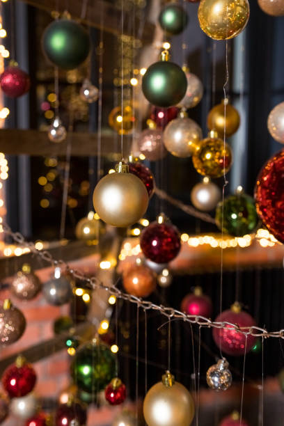 istock A group of Christmas balls hanging on thin threads on blurred background. Happy new year theme. greeting card.Colorful Christmas small balls hang on ribbons 1321363708
