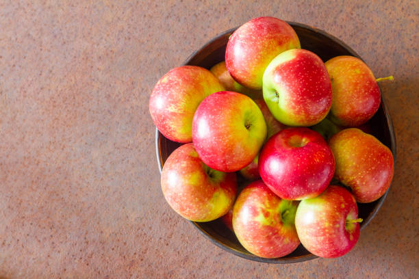 Fresh apples on a metal plate against a rusty metal surface. Top view. Closeup, selective focus