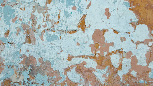 istock Old concrete wall with crumbling blue and orange paint, 1321366097