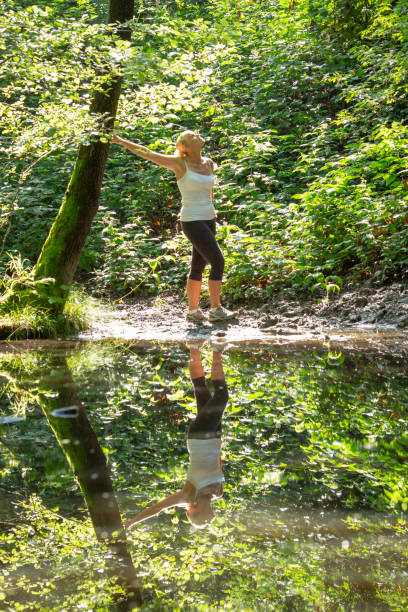 istock Woman enjoys leafy green pond in springtime 1321367094