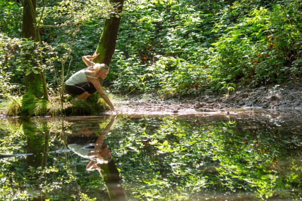 istock Woman enjoys leafy green pond in springtime 1321367158