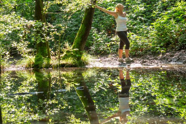 istock Woman enjoys leafy green pond in springtime 1321367229