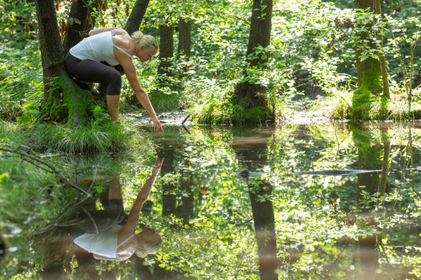 istock Woman enjoys leafy green pond in springtime 1321367230