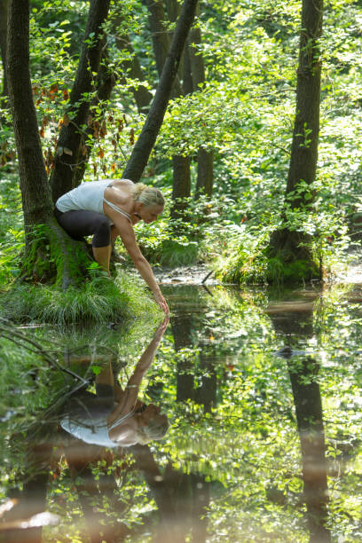 istock Woman enjoys leafy green pond in springtime 1321367232