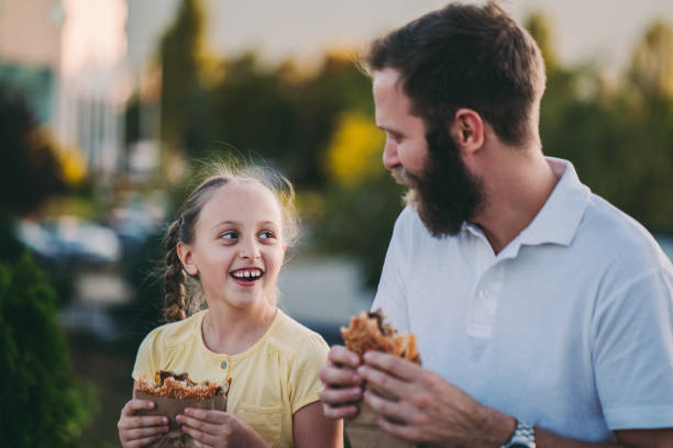 istock Father with daughter eating fast food 1321368452