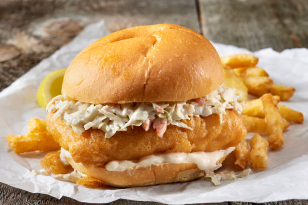 Beer Battered Fish Burger with Fries Beer Battered Fish Burger with Creamy Coleslaw, Tarter Sauce and Fries breaded photos stock pictures, royalty-free photos & images