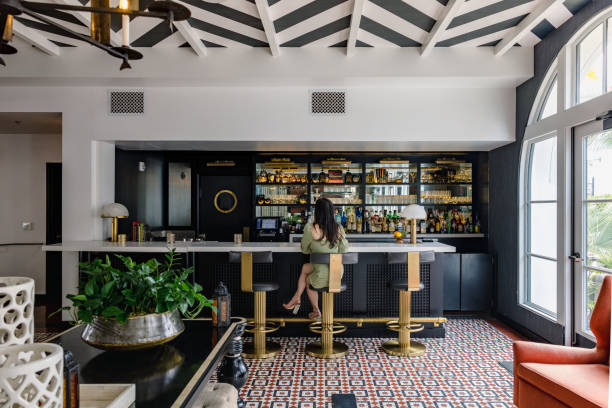 A dimly lit interior shot of a hi-fi Bar. The top shelves are filled with numerous vertically stacked records, and on a lower shelf, there are several wine glasses, drinking glasses, and various bottles.