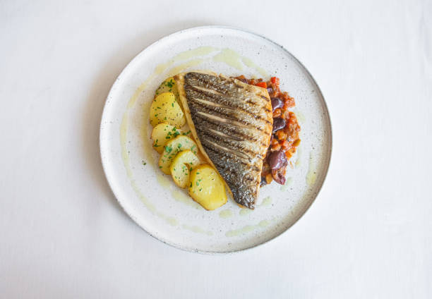 istock fried sea fish juicy dish potatoes vegetables 1321379547