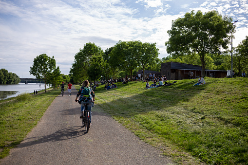 Angers, Maine et Loire, France - May 31 2021: cycling route in the city park, woman riding bicycle on bike lane in the park