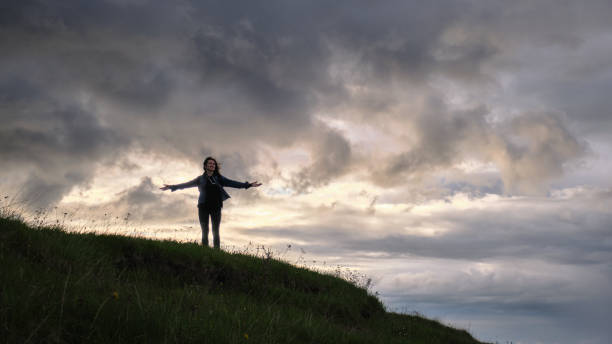 istock A girl walks through a meadow with plants in cloudy weather 1321386232