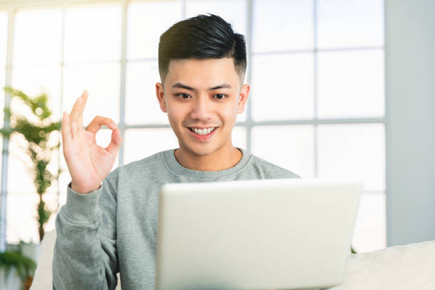 istock young man working with laptop at home and showing ok gesture 1321392493