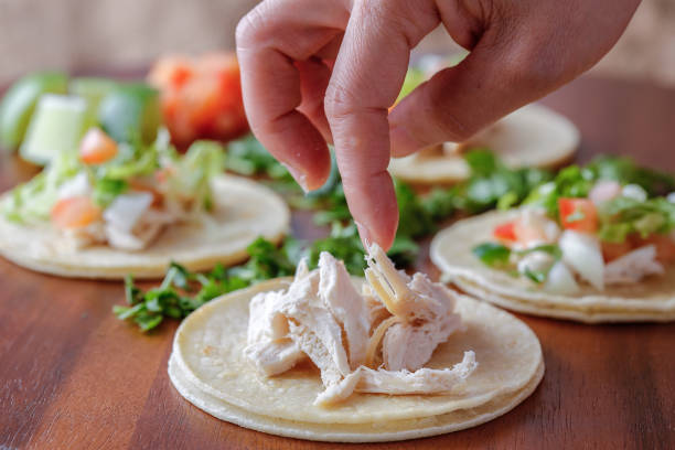 Adjusting the chicken on a small tortilla.