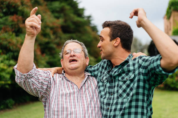 istock Father and adult son celebrating in their backyard 1321397492