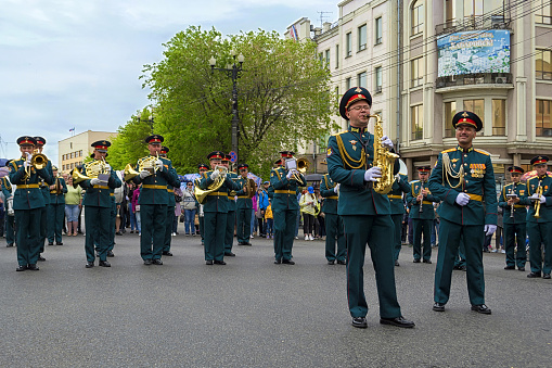 Khabarovsk, Russia - May, 2020: Brass band street performance. Russian musicians in uniform are playing wind instruments on the parade. International festival of military bands \