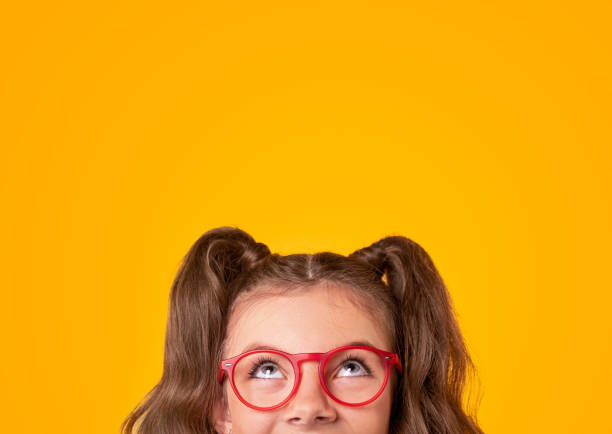 szczęśliwa dziewczyna w modnych okularach patrząc w górę - child glasses eyewear little girls zdjęcia i obrazy z banku zdjęć