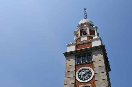 Hong Kong, China - August 9, 2019: Top part of the Clock Tower in Tsim Sha Tsui, also known as the Former Kowloon-Canton Railway Clock Tower and Tsim Sha Tsui Clock Tower.