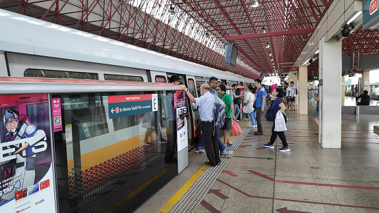 Singapore, 31 Mar, 2020: Passengers board into Singapore Mass Rapid Transit (MRT) train in Jurong East station in Singapore.