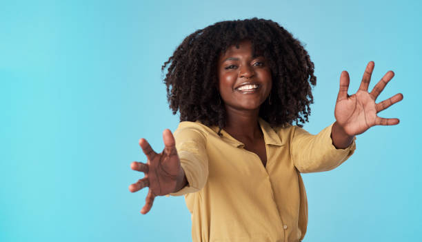 Studio shot of an attractive young woman extending her arms against a blue background My arms were made for hugging huge black woman pictures stock pictures, royalty-free photos & images