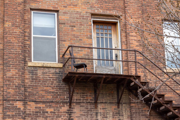 istock Weathered brick wall texture background with fire escape landing 1321406753