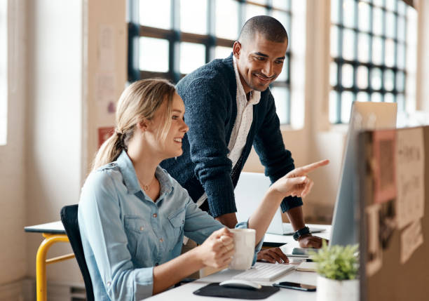 istock Shot of a young businessman using a computer with his colleague in a modern office 1321408547