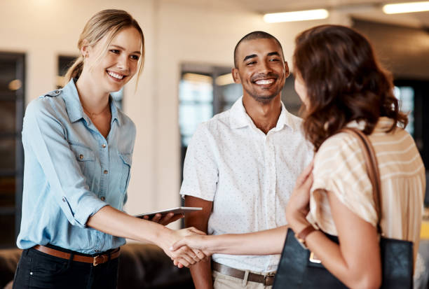 Shot of a young businesswoman shaking hands with a colleague during a meeting in a modern office It's a pleasure to have you join us casual handshake stock pictures, royalty-free photos & images