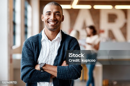 istock Portrait of a confident young businessman working in a modern office 1321409713