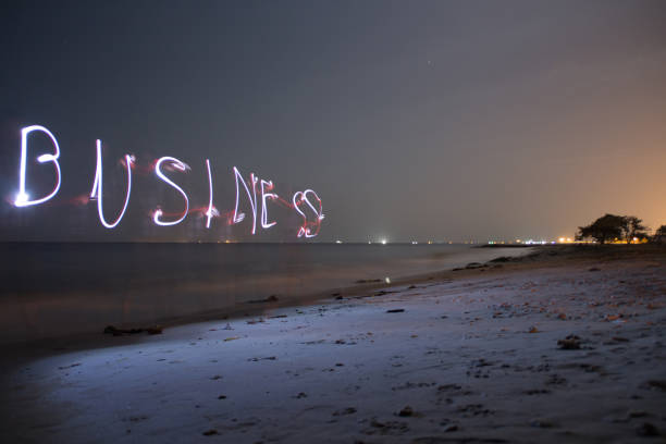 istock A business word made it with a light during the night at the beach 1321412029