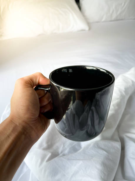 istock a man hold a black cup of coffee in bed 1321422457