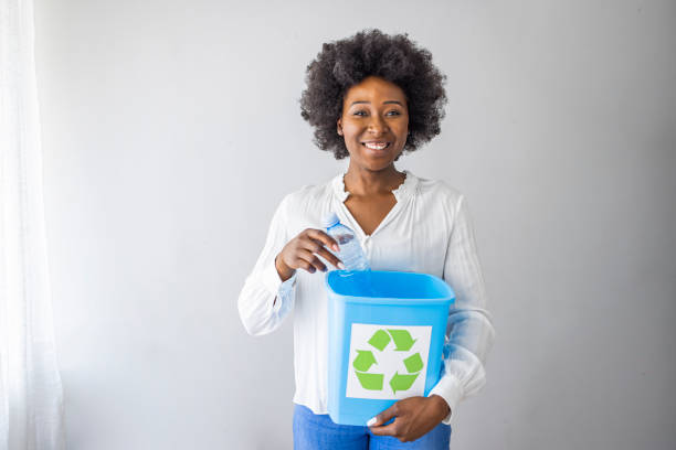istock A woman collecting and separating recyclable garbage plastic bottles into a trash bin at home. 1321422483