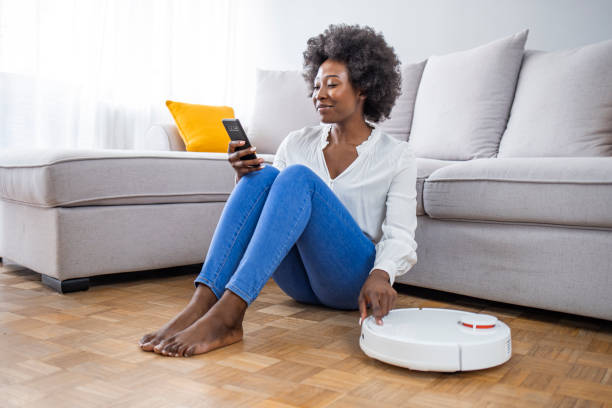 istock Girl turning on robot vacuum cleaner. 1321425113