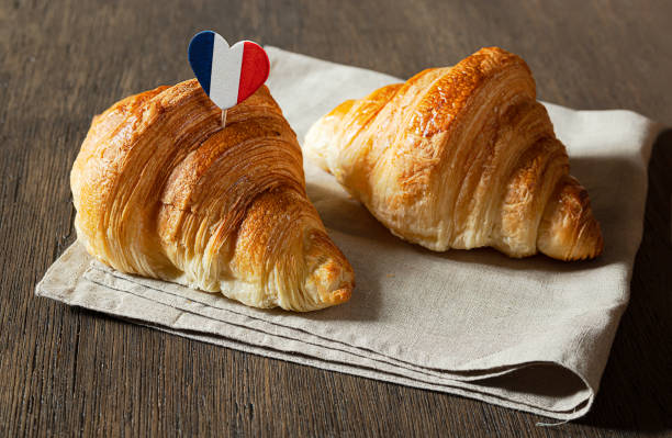 Two fresh croissants on a table Two fresh french croissants and a heart in the colors of the French flag on a table french flag stock pictures, royalty-free photos & images