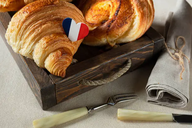 Photo of Croissants in a tray and cutlery
