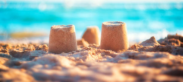 istock sand castle on the seashore against a backdrop of blurry blue waves. summer background 1321426366