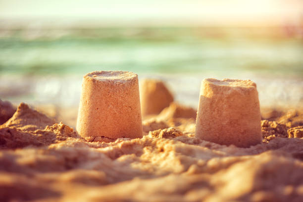 istock sand castle on the seashore against a backdrop of blurry blue waves. summer background 1321426401