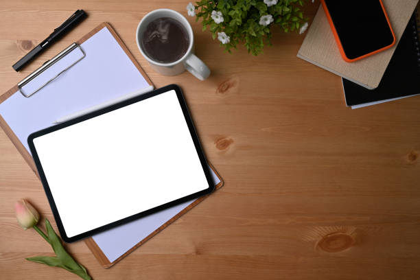 istock Digital tablet with blank screen, coffee cup, smart phone, houseplant and notebook on wooden background. 1321428441