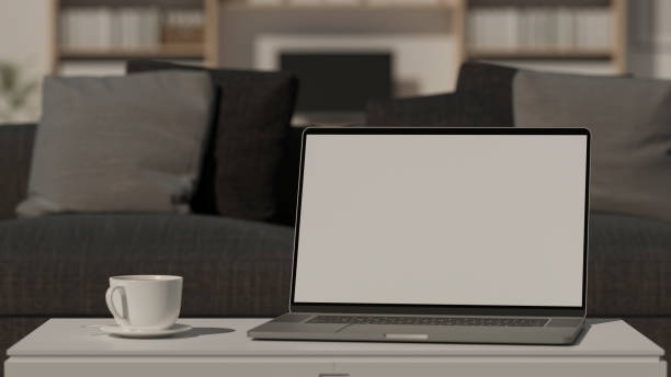 istock Computer laptop with mock-up screen on coffee table in living room, 3D rendering 1321430786
