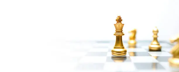 Concept of leadership. Golden king chess on the board on white background. Abstract images show business leadership with copy space.