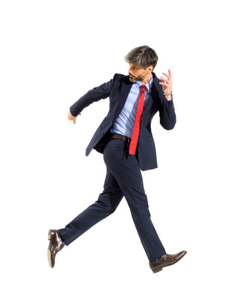 Jubilant successful stylish businessman walking on air looking back over his shoulder in a conceptual image of the idiom isolated over a white studio background