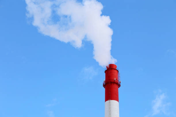 青い空と白い煙と雲の背景に工場の煙突 - global warming city smog heat ストックフォトと画像