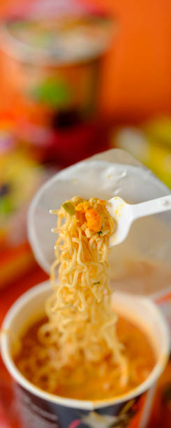 istock Hot, ready to eat, Asian instant cup noodles on the plastic fork that comes with the cup. 1321434937