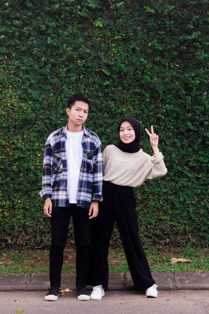 Happy Young Couple In Garden, teenage couple Indonesian Happy Young Couple In Garden, teenage couple Indonesian malay couple full body stock pictures, royalty-free photos & images