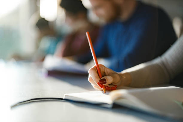 istock Close up of unrecognizable college student writing in a notebook. 1321439410