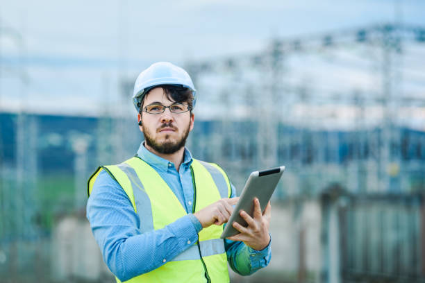 istock Electrical engineer working on a tablet in front of Electricity power station 1321439444