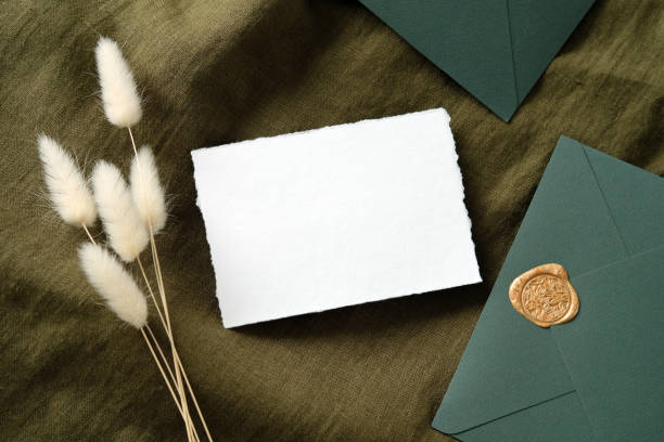 istock Rustic wedding stationery set top view. White invitation card mockup, envelopes, dried flowers on green fabric. Flat lay, top view, copy space. 1321439716