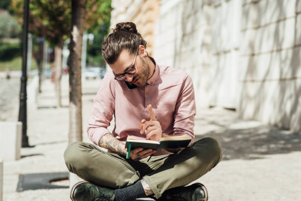 istock Young man learning and talking on the phone in the city 1321439908