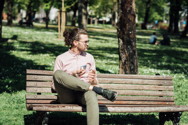 istock Young man in the park taking a break and using smartphone 1321439918