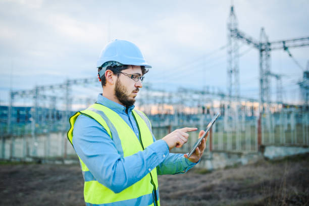 istock Electrical engineer working on a tablet in front of Electricity power station 1321441115