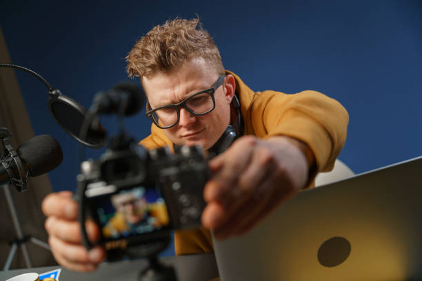 istock A blogger takes a video himself in a studio with a dark blue background 1321443339
