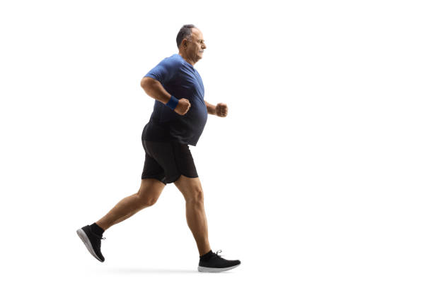 Full length profile shot of a corpulent mature man in sportswear running Full length profile shot of a corpulent mature man in sportswear running isolated on white background chubby arab stock pictures, royalty-free photos & images